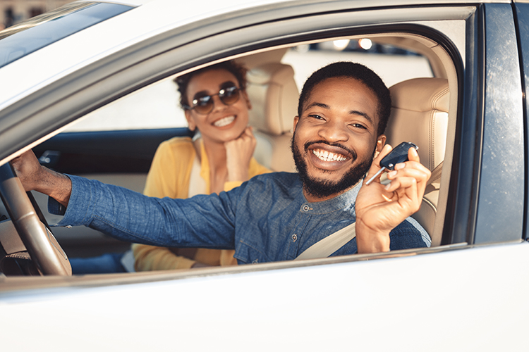 Young African American couple smiling before driving off in their new car | Metro East, IL