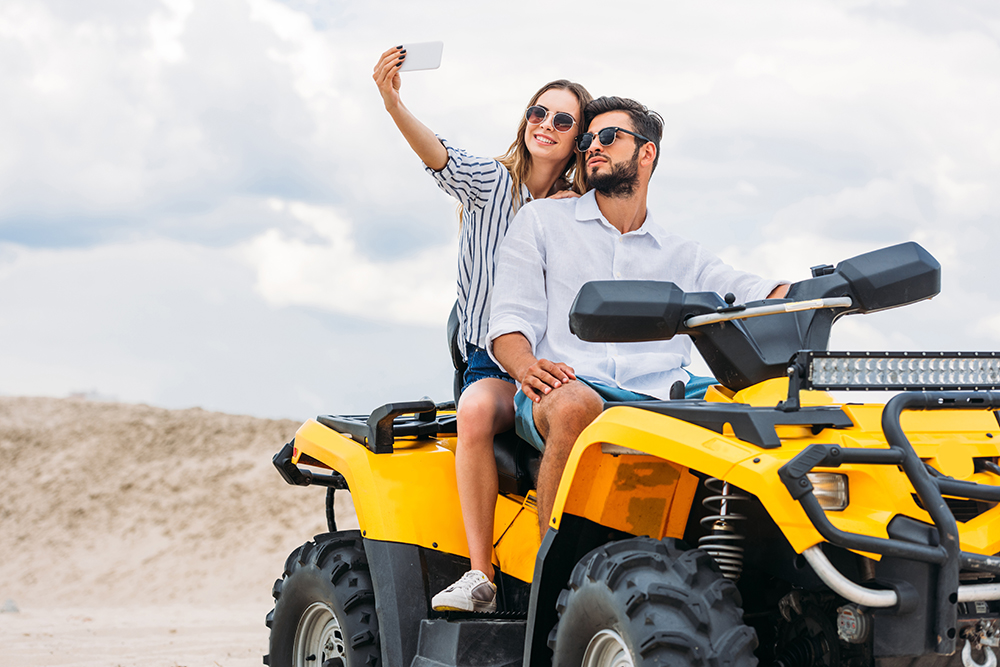 attractive young couple taking selfie while sitting on a yellow ATV | Metro East, IL